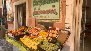 A vibrant display of fresh fruits outside an Italian store, showcasing local produce.